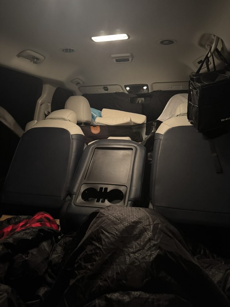 Packed SUV trunk set up for sleeping during a cold night of car camping