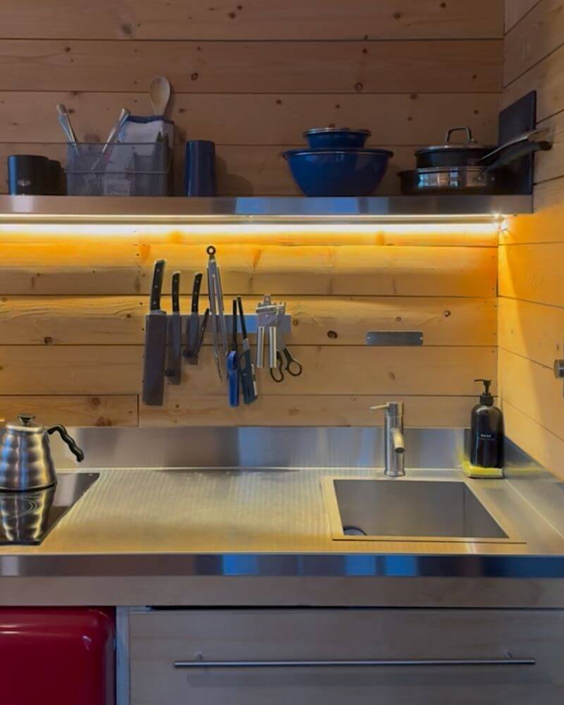 Kitchen sink, induction cooktop, and hanging cookware inside a Getaway cabin
