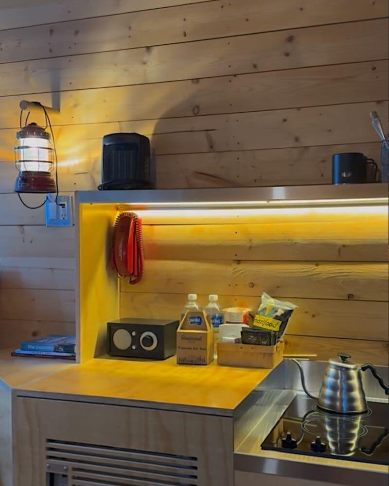 Compact kitchenette counter with pour over kettle induction stove and mini fridge inside Getaway cabin