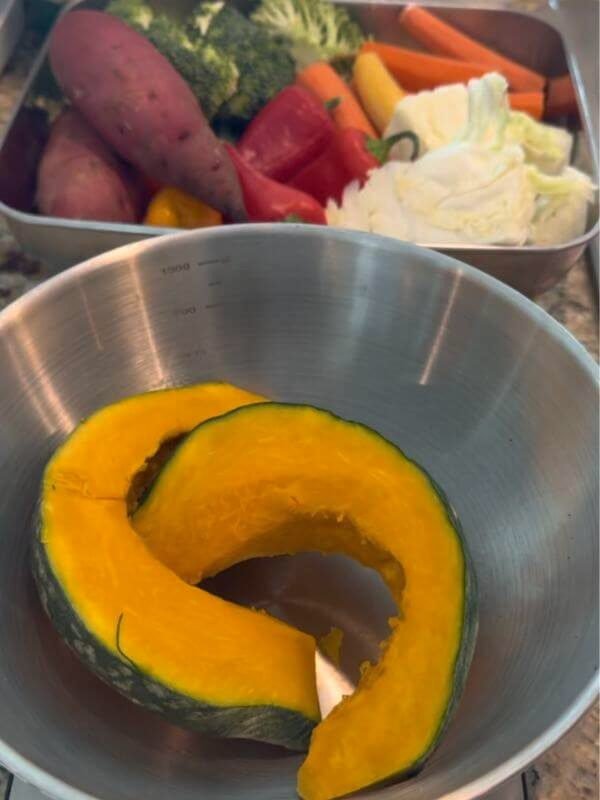 Measuring fresh kabocha pumpkin, carrots, and sweet potatoes on a kitchen scale