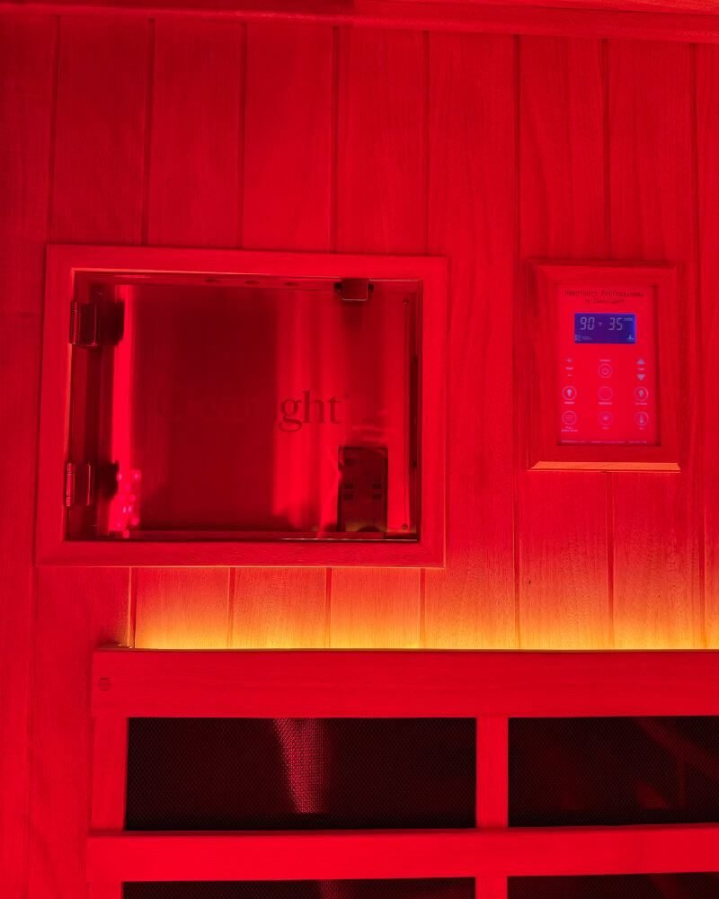 Digital control panel showing temperature and timer settings inside a red light therapy sauna