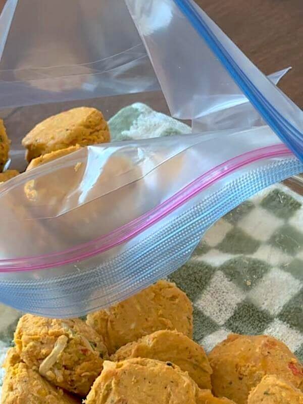 Individually frozen homemade dog food scoops stored together in a Ziploc freezer bag without sticking