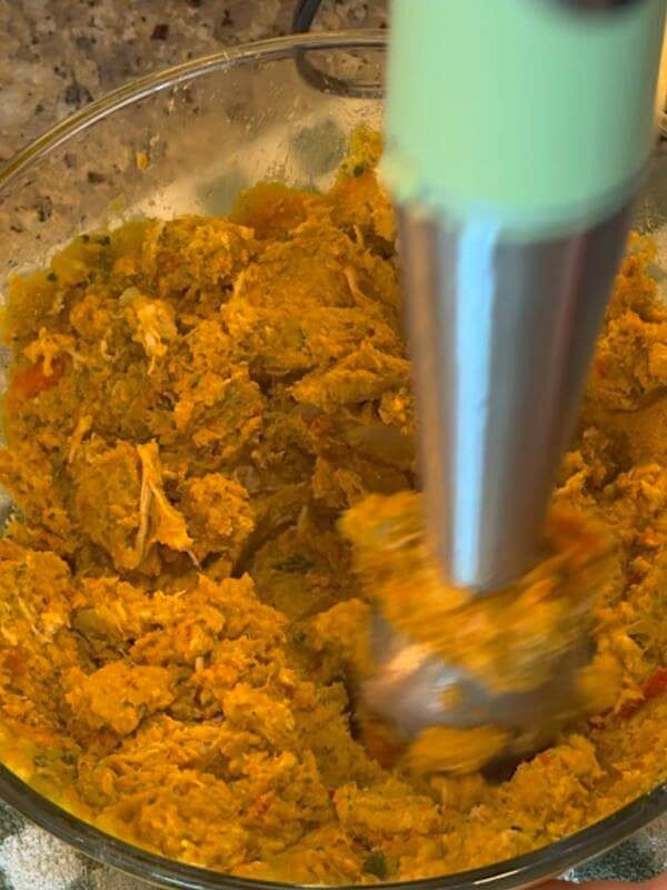Texture of pulse chopped homemade chicken and vegetable dog food mixture in a glass bowl