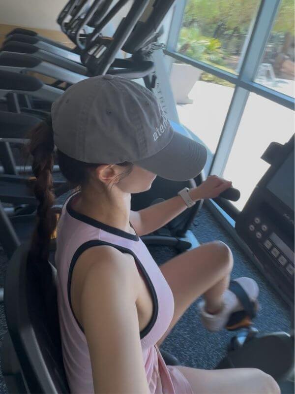 My Wellness Morning Routine: From Exhausted to Energized Woman doing Zone 2 cardio on a stationary bike at the gym