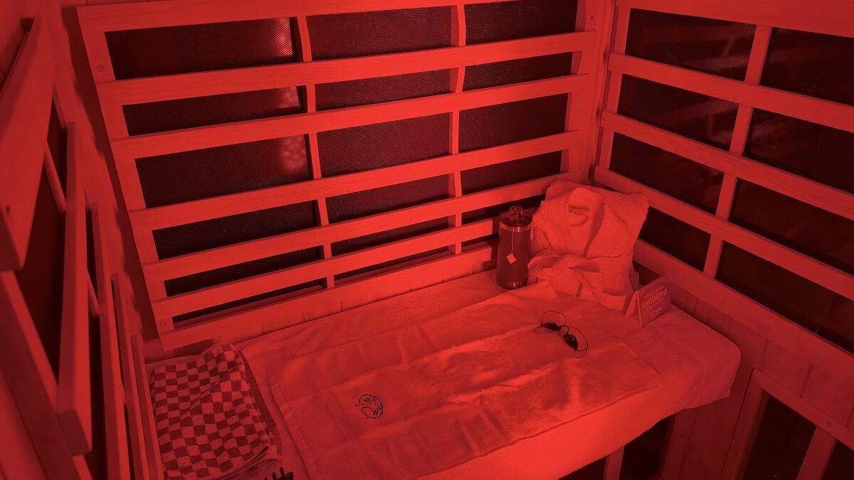 The inside of a full spectrum booth lit in deep red, where I worked out how long in a red light sauna should be for me