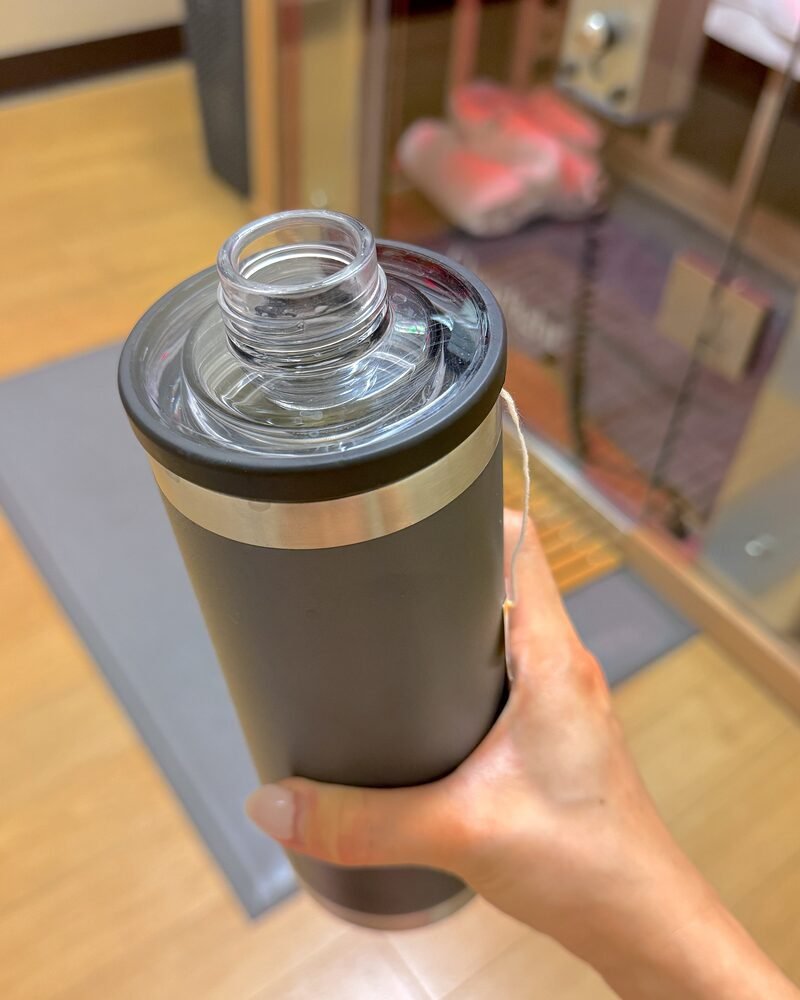 How to Cool Down After a Sauna Session When There Is No Shower A hand holding a stainless tumbler immediately after stepping out of a forty minute sauna session