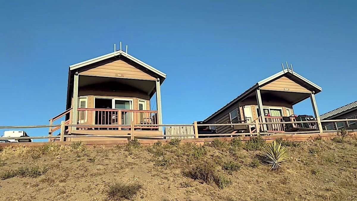 Wooden ocean-view rental cabins on a grassy bluff at Jalama Beach County Park