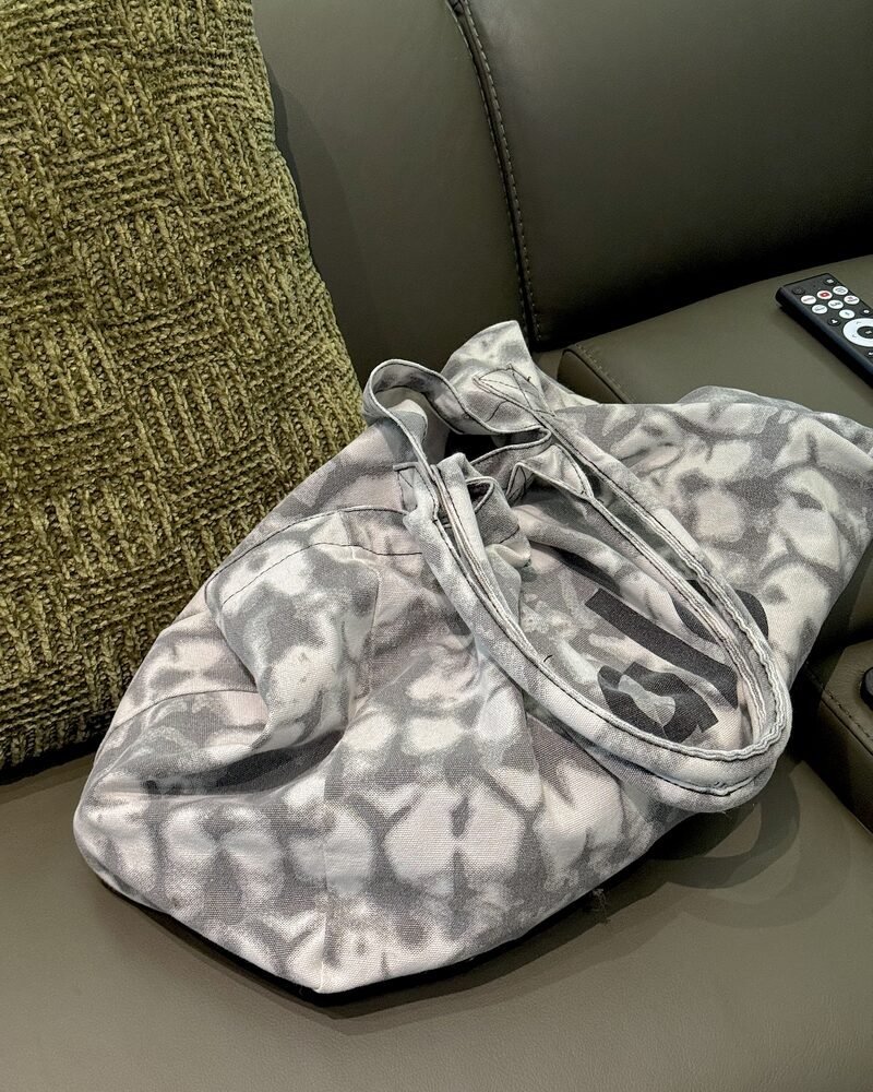 A packed tote bag sitting on a chair, ready for a morning infrared sauna session