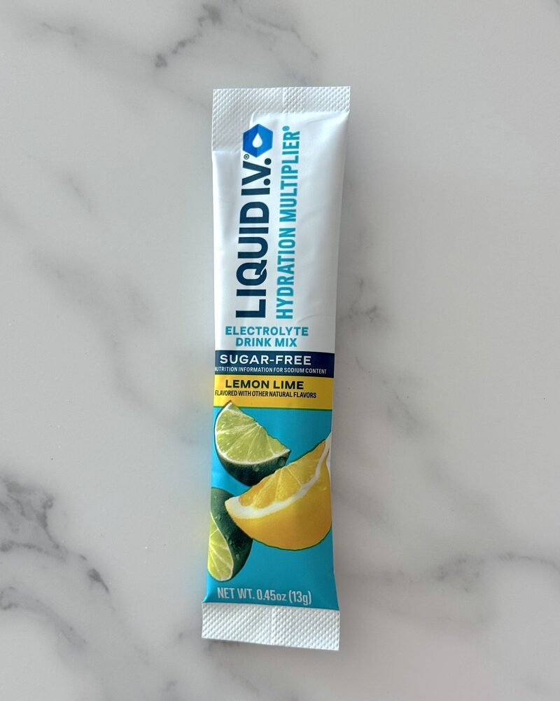 A single sugar free lemon lime electrolyte stick pack on a marble counter, label facing forward