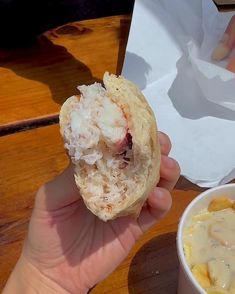 Westside Regional Park Camping With Dogs: What We Wish We'd Known Cup of clam chowder with oyster crackers and a crab sandwich on a wooden table at Spud Point Crab Co