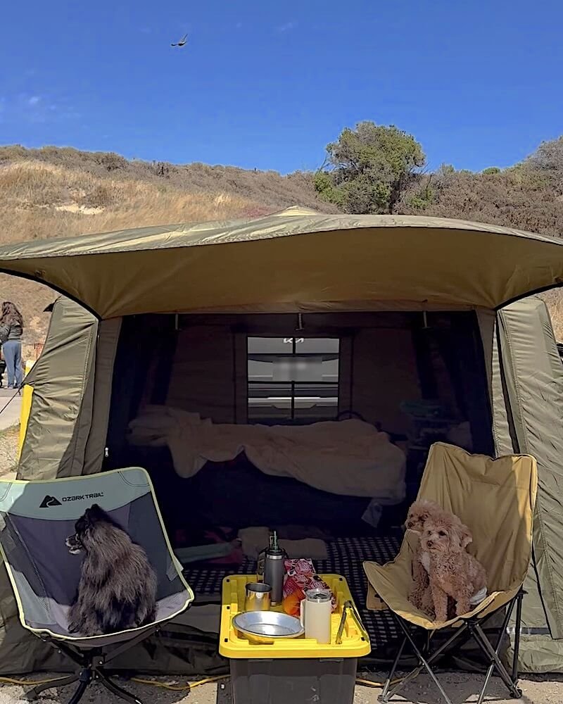 Inflatable air tent with an awning staked out over camp chairs and a cooler at a Jalama Beach campsite
