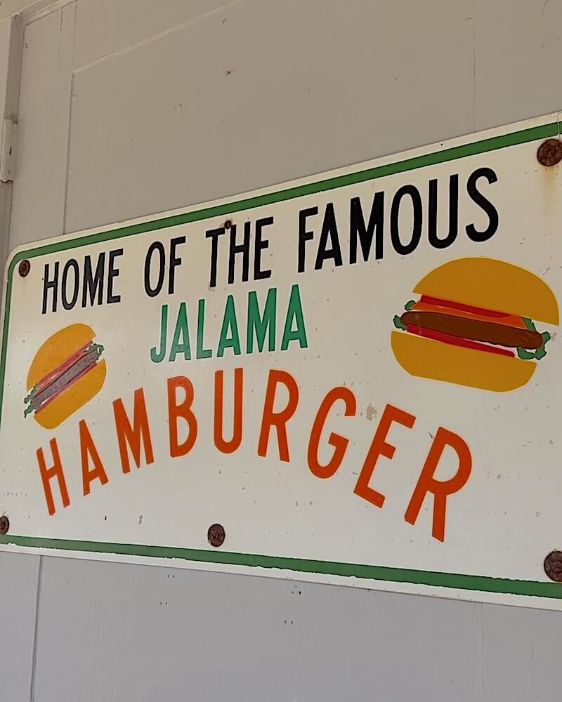 Hand-painted sign reading Home of the Famous Jalama Hamburger on the wall of the Jalama Beach Store