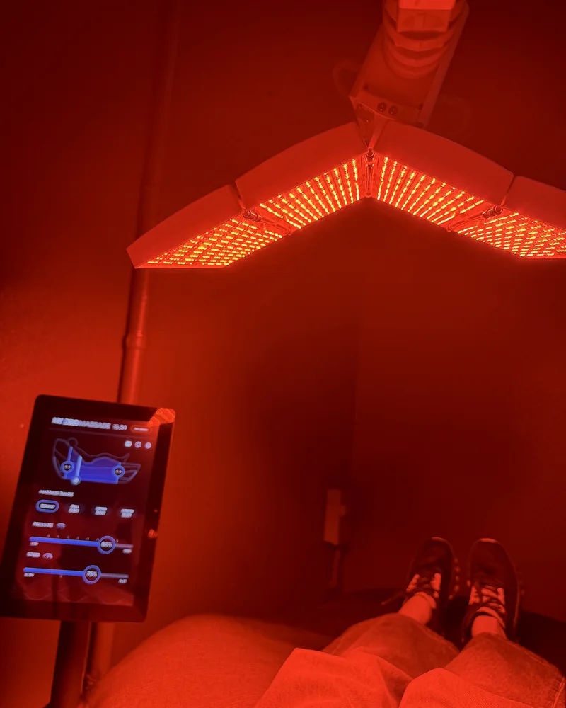 Hydromassage Bed: My Honest Review After 10+ Sessions (and the Exact Settings I Use) Hydromassage bed with a red LED face panel above it and a touchscreen tablet on a stand