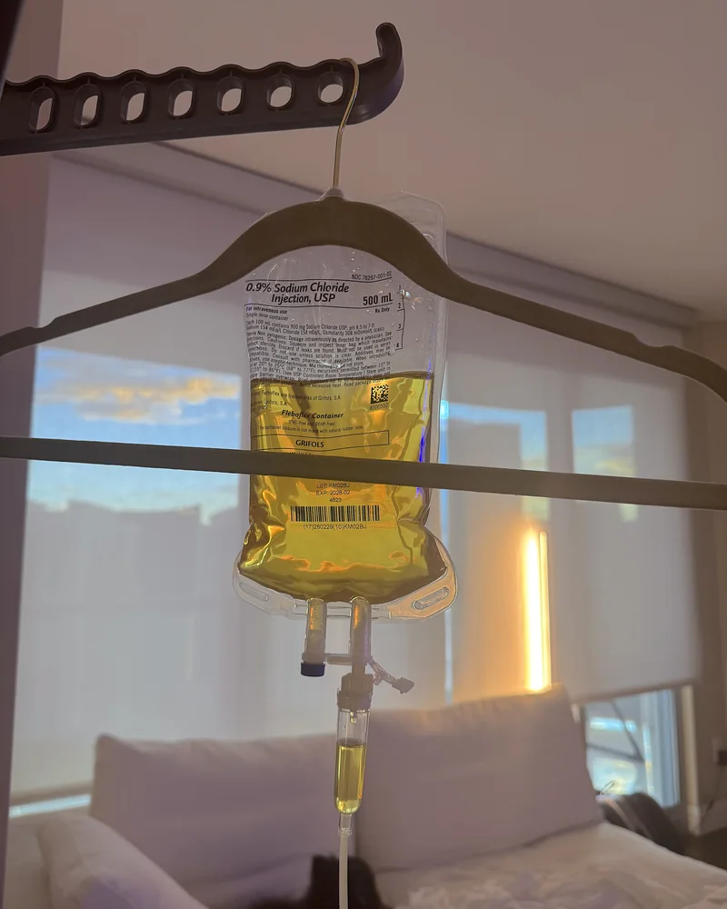 NAD IV Therapy: What My First 1,000 mg Drip Was Like (And the Week After) NAD IV therapy at home: a 500 mL saline bag mixed with vitamins and NAD hanging from a clothes hanger by the window