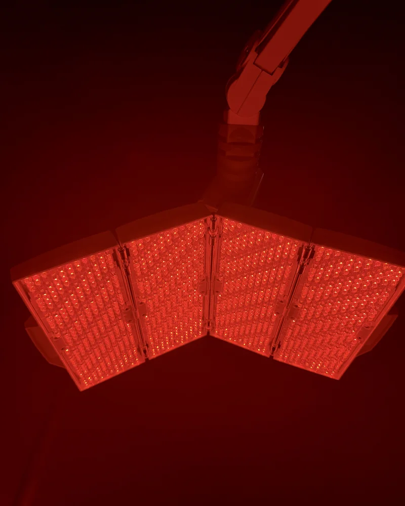 Tanning Salon Red Light Therapy: My Honest Routine After 10+ Face Sessions Tanning salon red light therapy face panel glowing red in a dark room