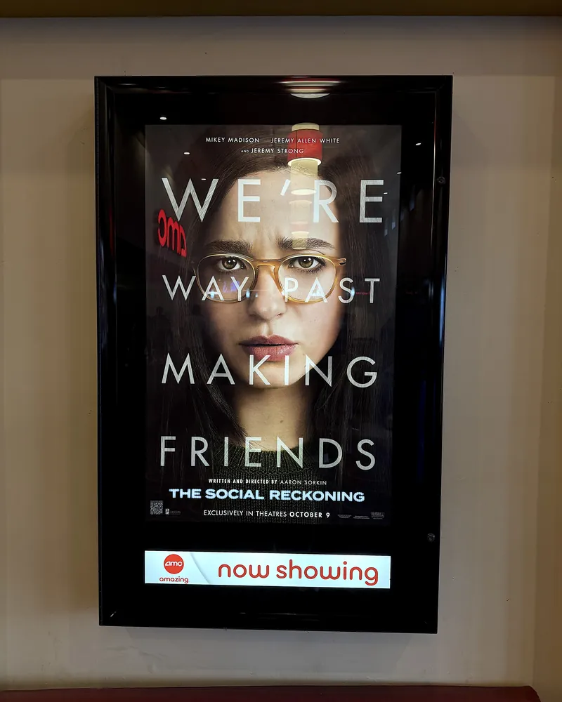 Is The Social Reckoning Worth Seeing? My 7.5/10 Review (No Spoilers) Is The Social Reckoning worth seeing: the movie poster in a lighted frame with a now showing sign at an AMC theater