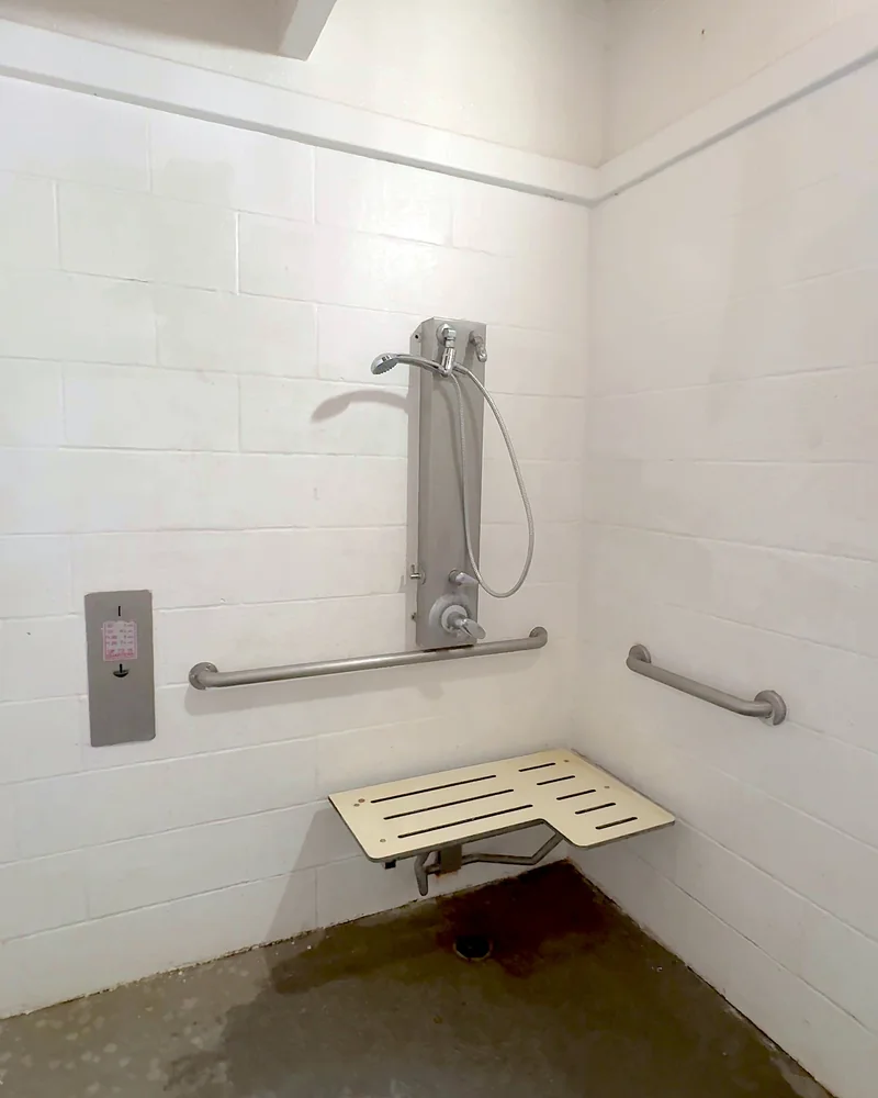 Truck Stop Showers: What Our First Pilot Shower Was Really Like (and What It Cost) Campground shower room with a handheld shower, grab bars and a fold-down seat