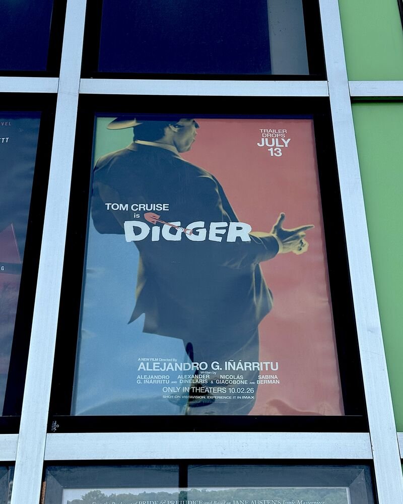 Digger movie poster with Tom Cruise from behind, displayed in a movie theater window