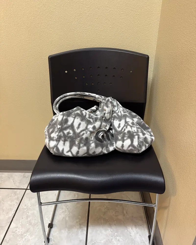 Infrared Sauna Cost: My $69.99 Membership vs Buying One (With Red Light) My tie-dye tote bag sitting on a black chair inside the private sauna room