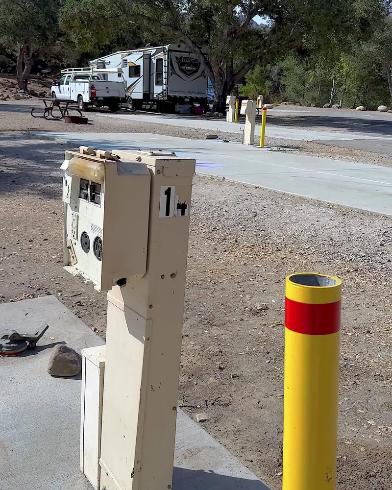 Steckel Park Camping With 3 Dogs: Our Honest Review of This Oak-Shaded Campground Electric and water hookup post next to a yellow safety pole at a campsite