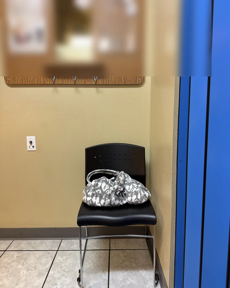 Infrared Sauna Cost: My $69.99 Membership vs Buying One (With Red Light) The private sauna room with a mirror, wall hooks, a chair and the blue door of the booth