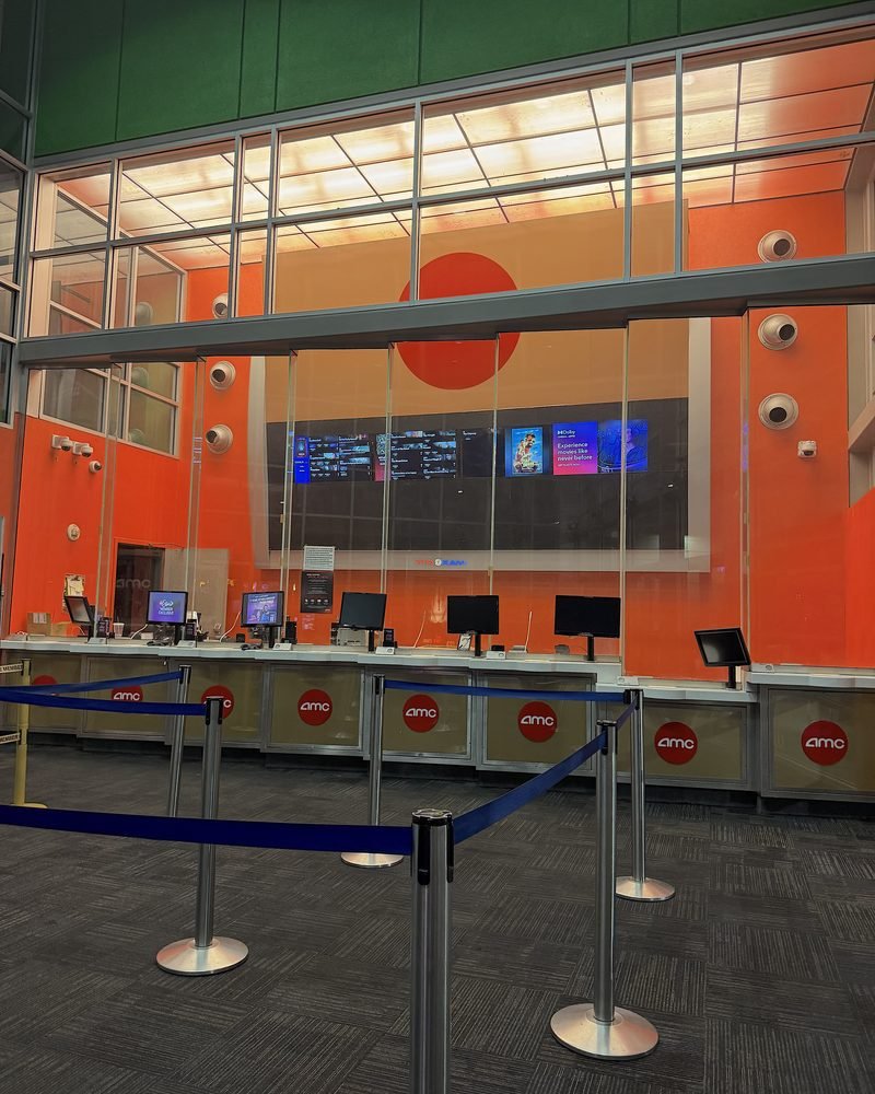 Empty AMC box office kiosks with stanchions in front on a weeknight