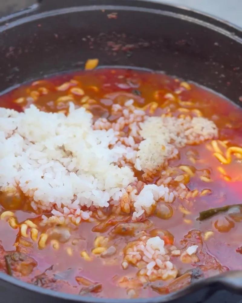 Camping Food List: What We Actually Ate in 3 Nights (Korean Dinners, Drinks, and the Dogs' Food) Rice stirred into spicy ramen broth in the kimchi stew pot