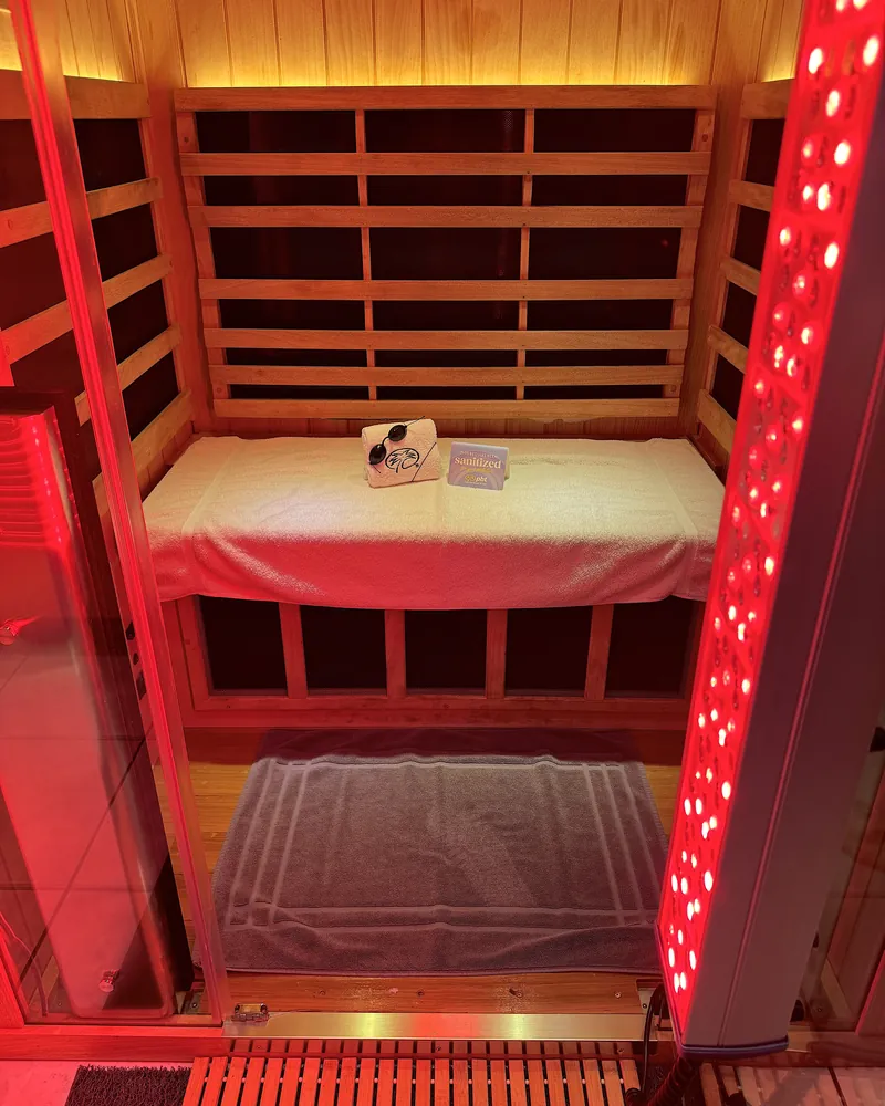 Infrared Sauna Cost: My $69.99 Membership vs Buying One (With Red Light) The infrared sauna booth with a tall red light tower glowing on the right side