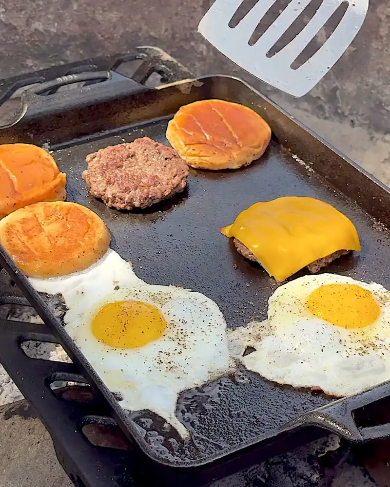 Easy Camping Breakfast: 4 Campfire Griddle Meals We Made (Nothing Prepped at Home) Toasted burger buns, beef patties, cheese and fried eggs on one griddle