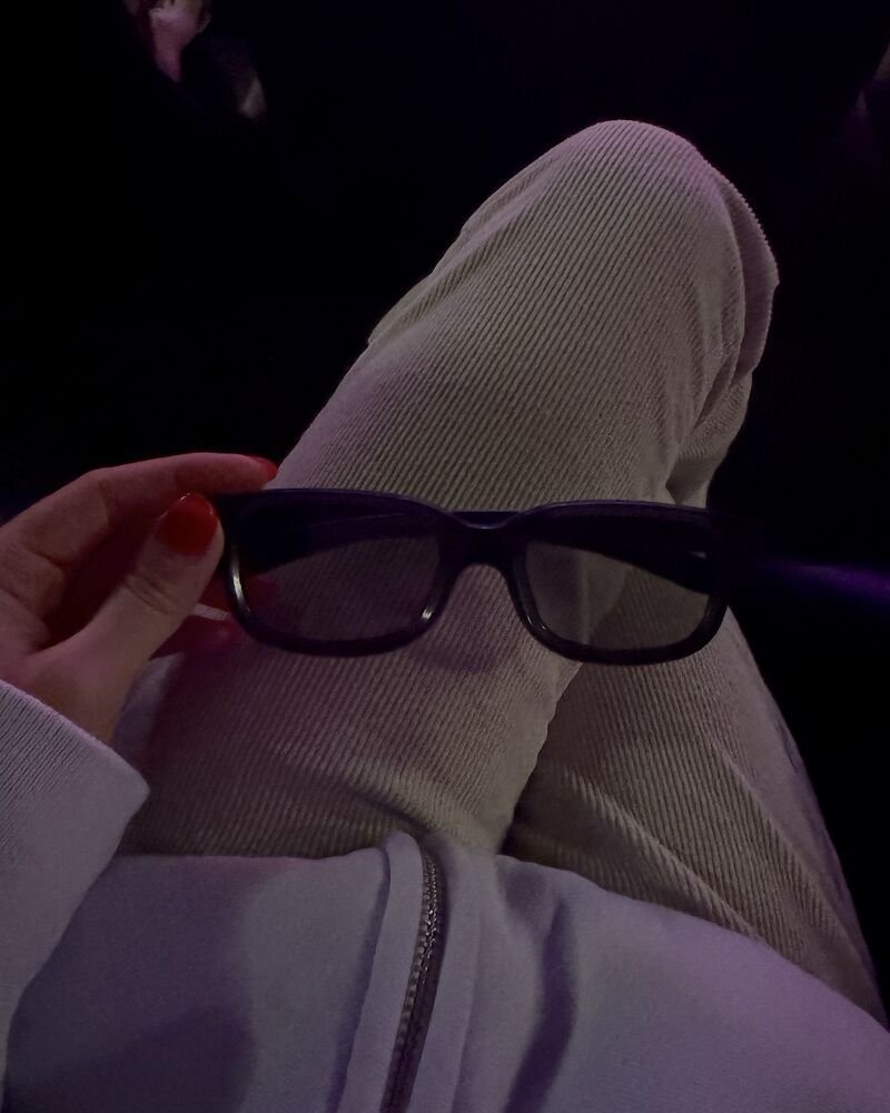 I Almost Skipped The Nightmare Before Christmas 3D. One Scene Changed My Mind Hand holding black 3D glasses in a dark movie theater before The Nightmare Before Christmas