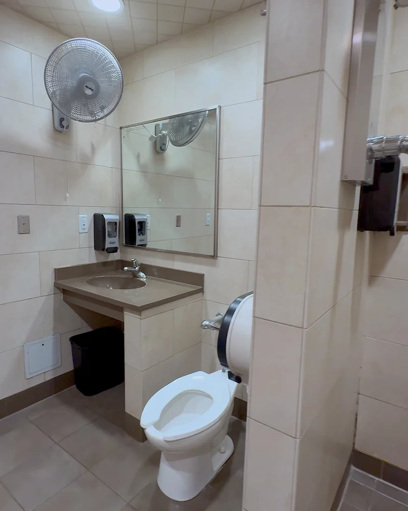 Truck Stop Showers: What Our First Pilot Shower Was Really Like (and What It Cost) Private shower room with a toilet, sink, mirror and wall fan