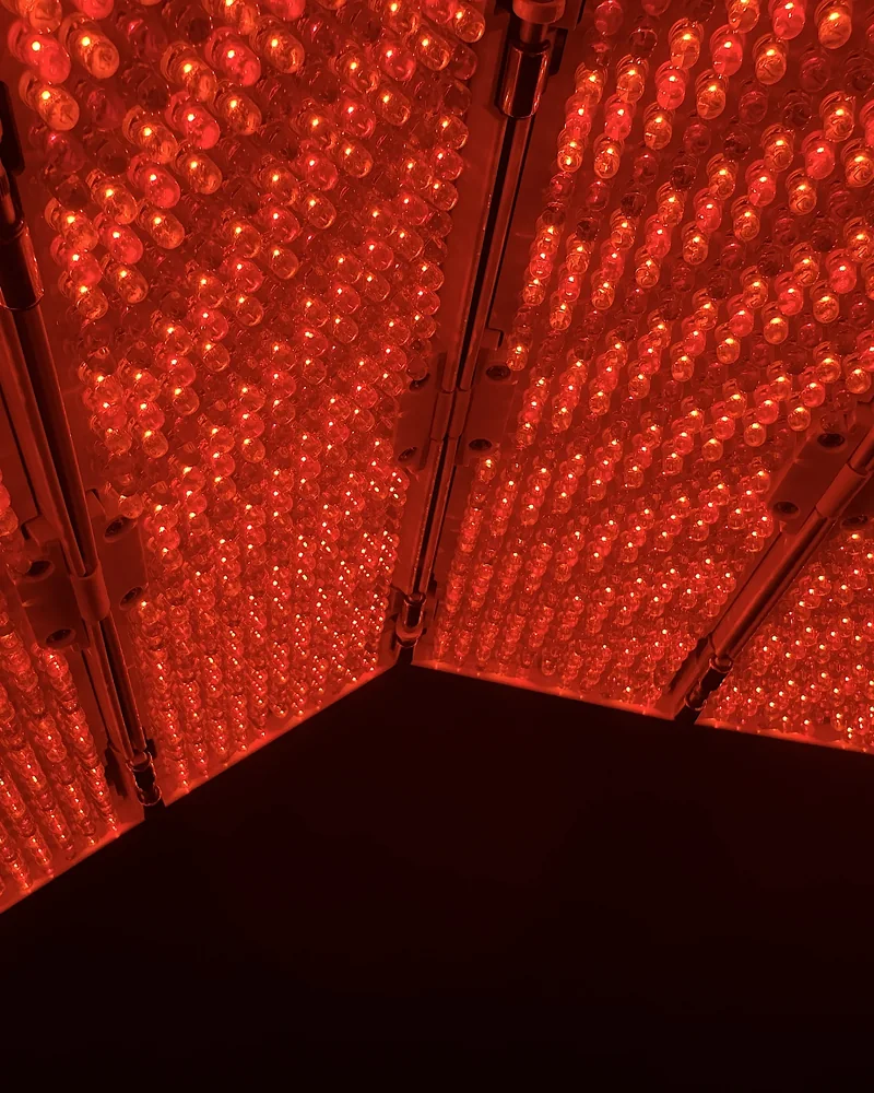 Tanning Salon Red Light Therapy: My Honest Routine After 10+ Face Sessions Close-up of rows of small red LED bulbs inside a face panel