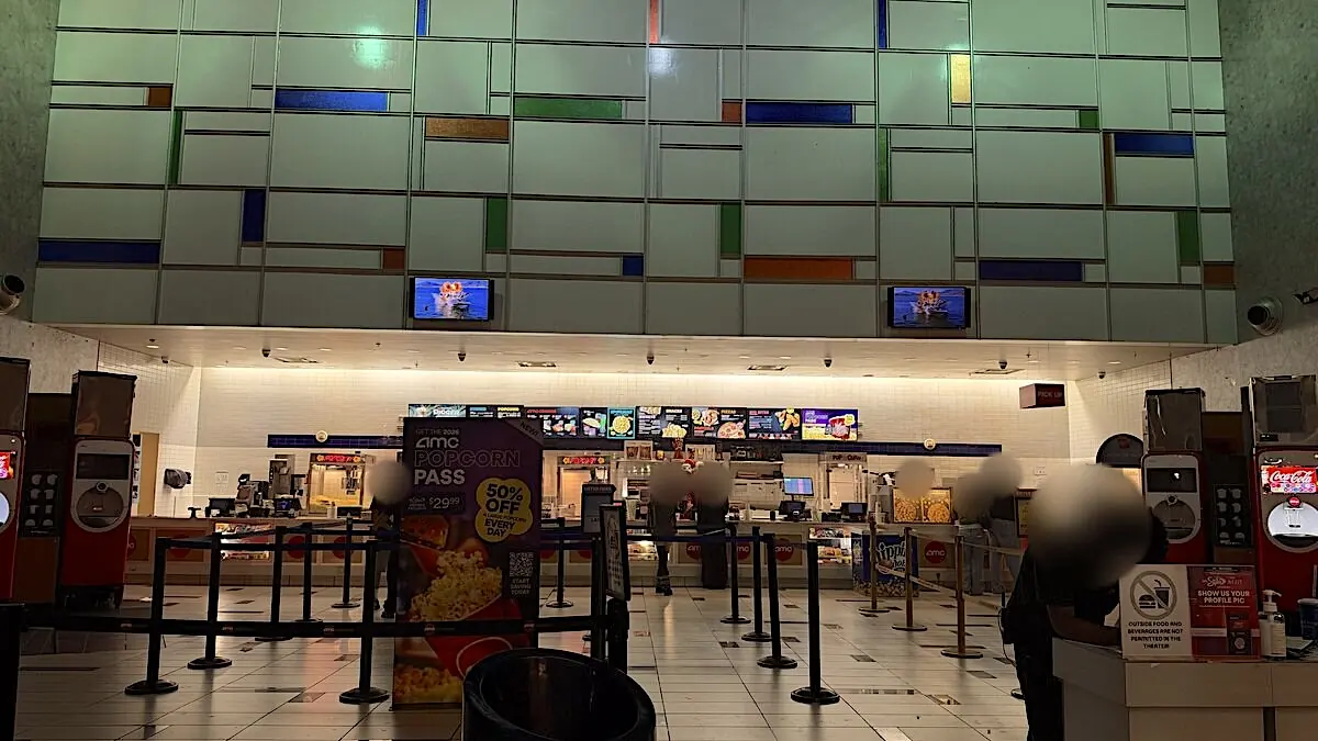 AMC concession stand with a Popcorn Pass poster and a short line on a Sunday night