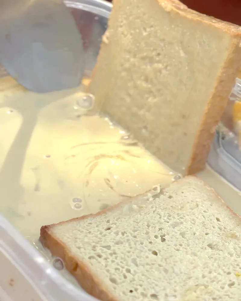 Easy Camping Breakfast: 4 Campfire Griddle Meals We Made (Nothing Prepped at Home) Thick slices of bread soaking in French toast batter in a plastic container