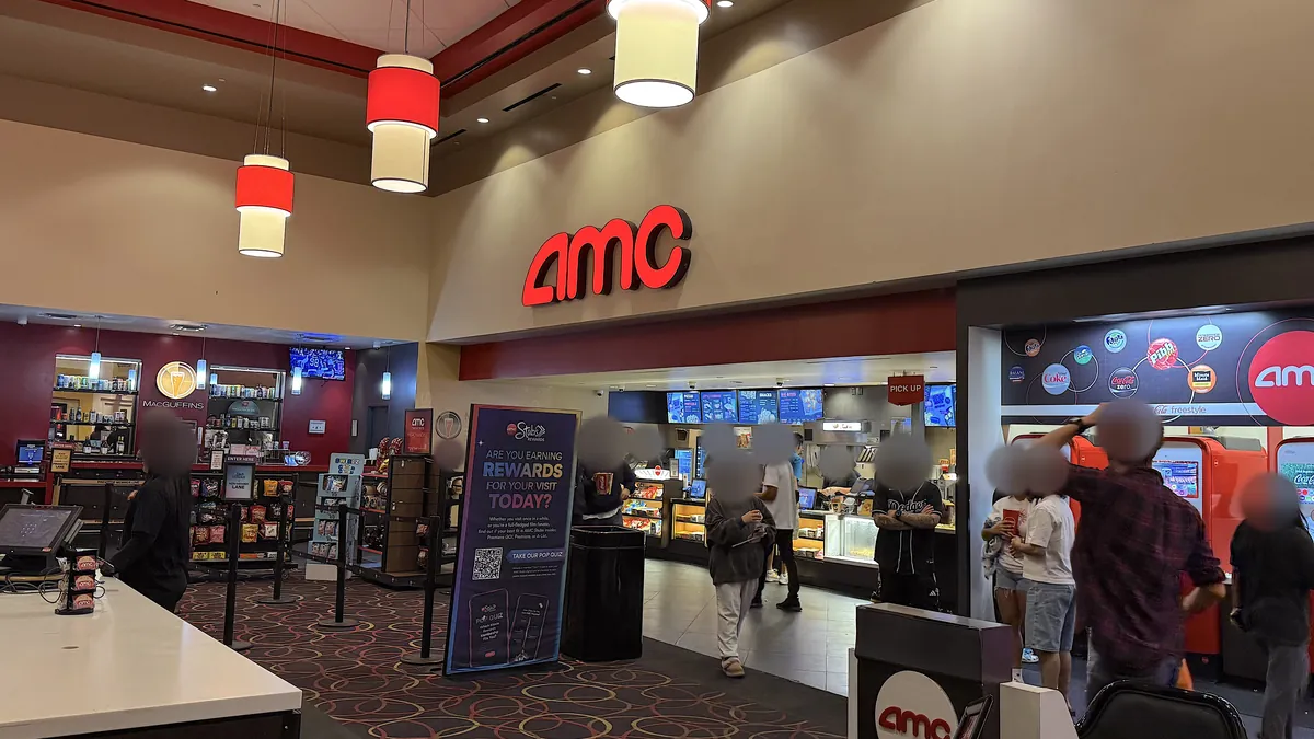 Is The Social Reckoning Worth Seeing? My 7.5/10 Review (No Spoilers) AMC theater lobby with the red AMC sign, pendant lights and the concession stand