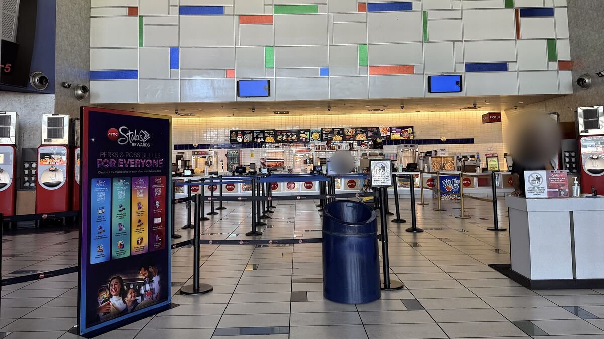 Quiet AMC movie theater lobby on a weekday afternoon with empty lines at the concession stand