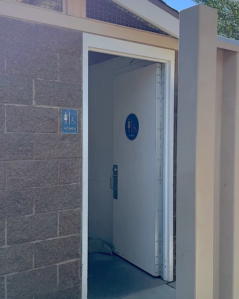 Steckel Park Camping With 3 Dogs: Our Honest Review of This Oak-Shaded Campground Open restroom door in a block building at the campground