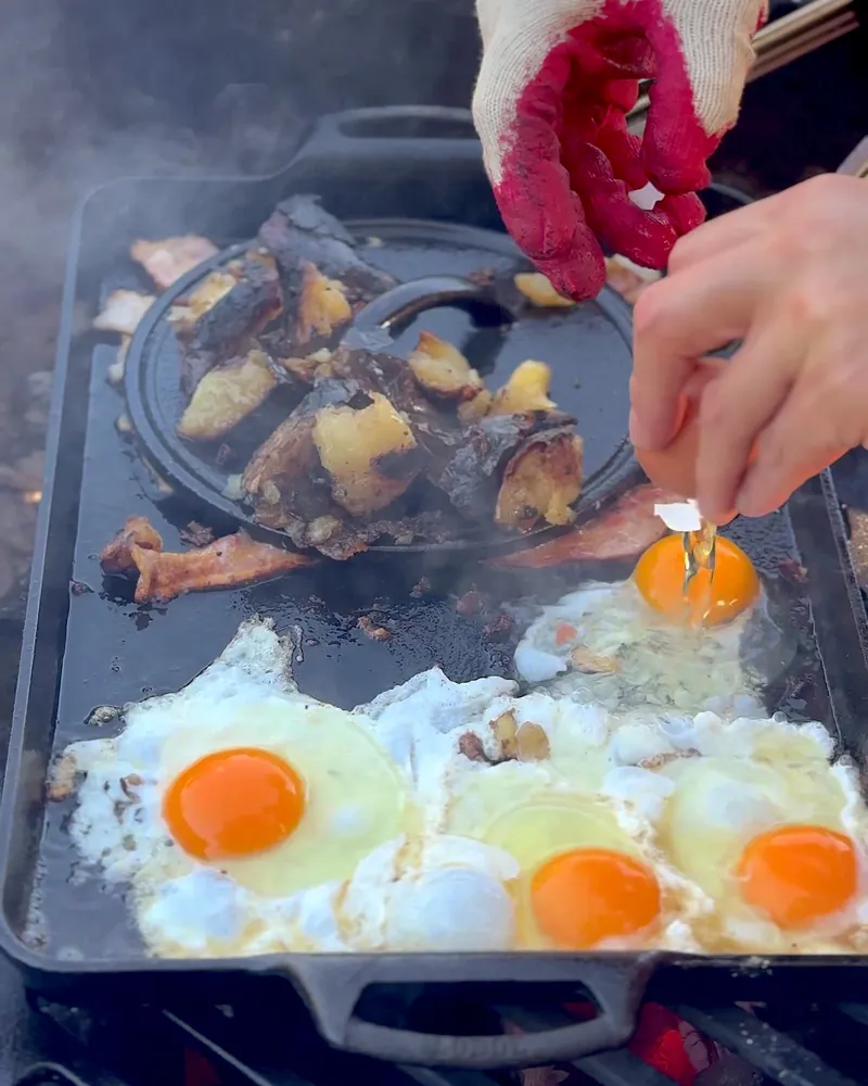 Easy Camping Breakfast: 4 Campfire Griddle Meals We Made (Nothing Prepped at Home) Bacon, fried eggs and potatoes cooking on a griddle over the campfire