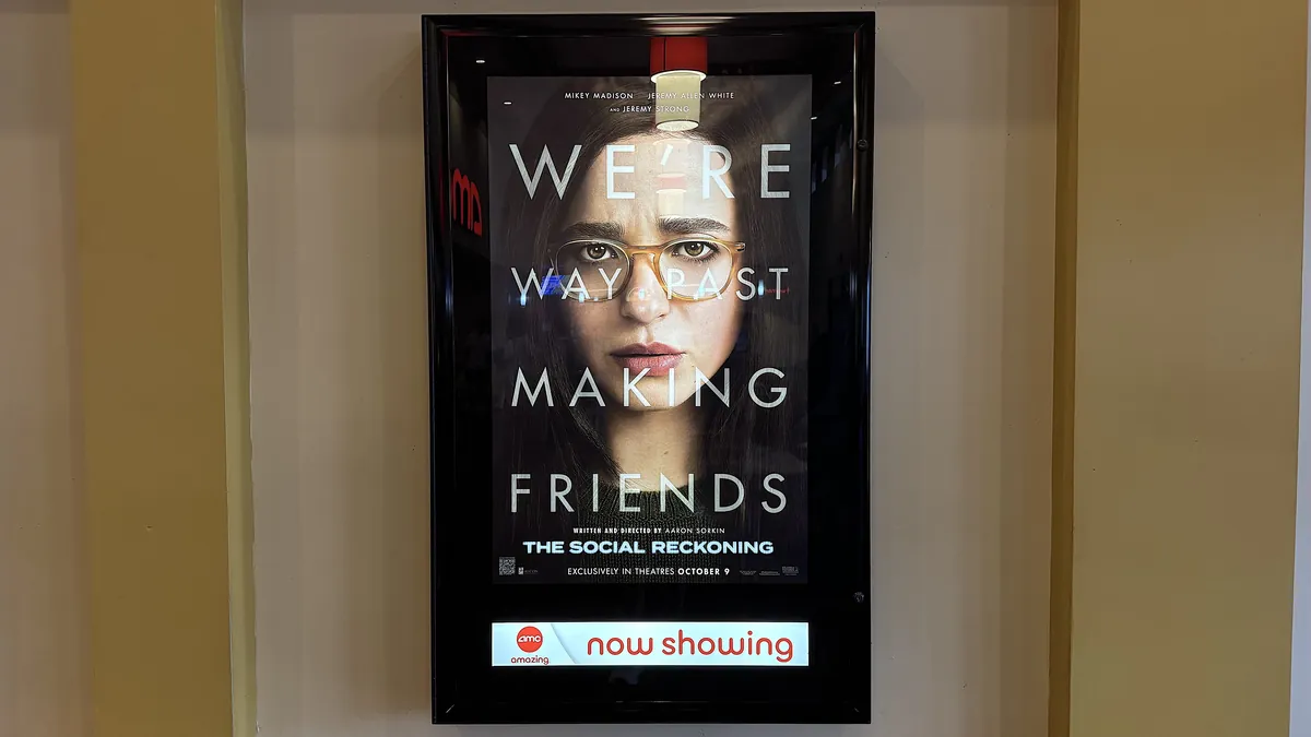 Is The Social Reckoning Worth Seeing? My 7.5/10 Review (No Spoilers) The Social Reckoning poster in a lighted frame with an AMC now showing sign on a theater wall