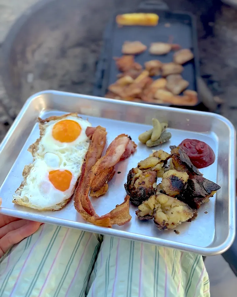 Easy Camping Breakfast: 4 Campfire Griddle Meals We Made (Nothing Prepped at Home) Camp breakfast plate with fried eggs, bacon, potatoes, mini pickles and ketchup