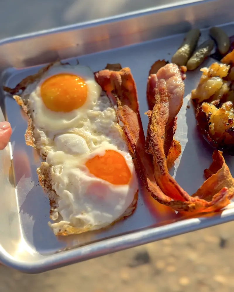 Easy Camping Breakfast: 4 Campfire Griddle Meals We Made (Nothing Prepped at Home) Close-up of two fried eggs and crispy bacon on a metal camp tray